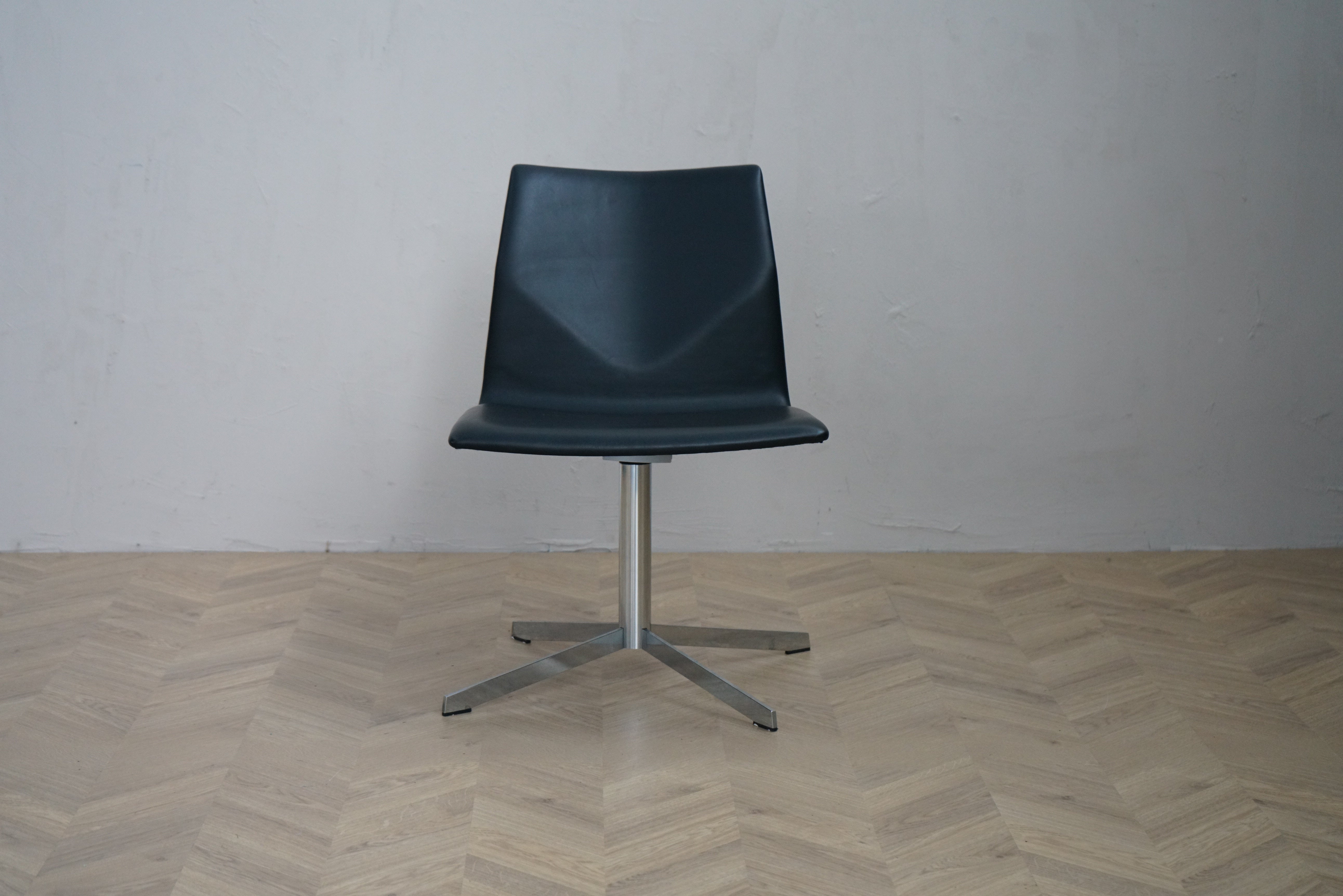 Four Design Four Cast loungestol i sort læder med drejefod i krom set forfra